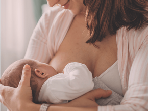 Smiling woman breastfeeding her baby