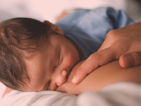 Top view of a baby sucking on mother's breast