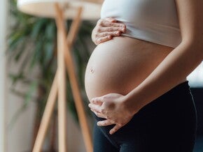 Primer plano de una mujer embarazada acariciándose el vientre. Contracciones en el embarazo.
