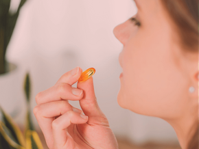 Side view of a woman taking a supplement