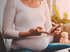 Pregnant woman doing a diabetes test with an epipen.