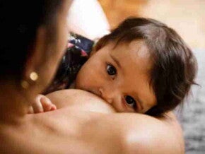 Bebé tomando leche del pecho de su madre Bebé tomando leche del pecho de su madre