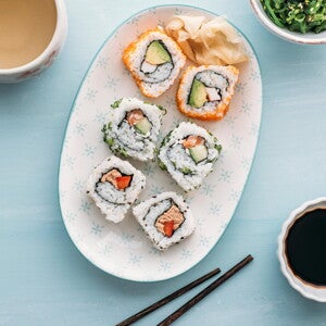 Sushi Bowl con Ensalada de Surimi y Batido Sushi en un bowl con palillos chinos a un lado