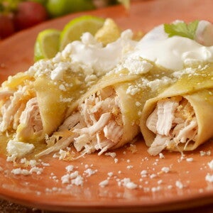 Burrito de Pollo con Salsa de Aguacate y Verduras Tres burritos de pollo con salsa en un plato marrón