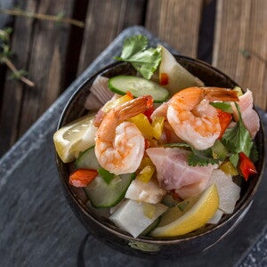 Ceviche Tropical con Surimi Un bowl con ceviche tropical y un limon al costado