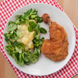 Milanesa de pollo empanizado con linaza Un plato que contiene pollo empanizado con una ensalada