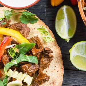 Tostadas de Fajitas de Res con Guacamole Fajitas rellenas con res y una salsa con limones a un lado