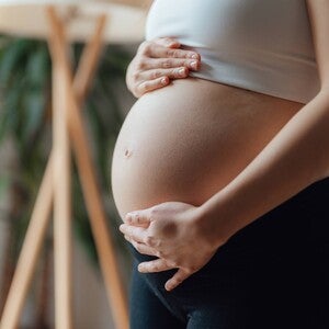 Primer plano de una mujer embarazada acariciándose el vientre. Contracciones en el embarazo.