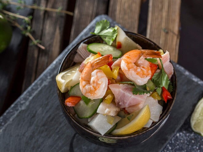 Ceviche Tropical con Surimi Un bowl con ceviche tropical y un limon al costado
