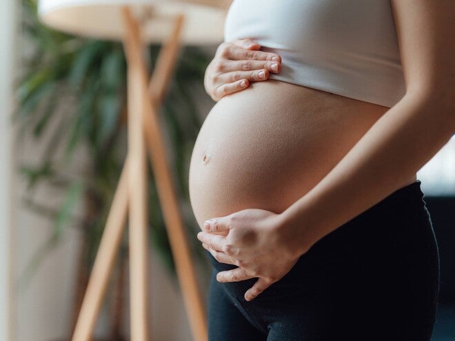 Primer plano de una mujer embarazada acariciándose el vientre. Contracciones en el embarazo.
