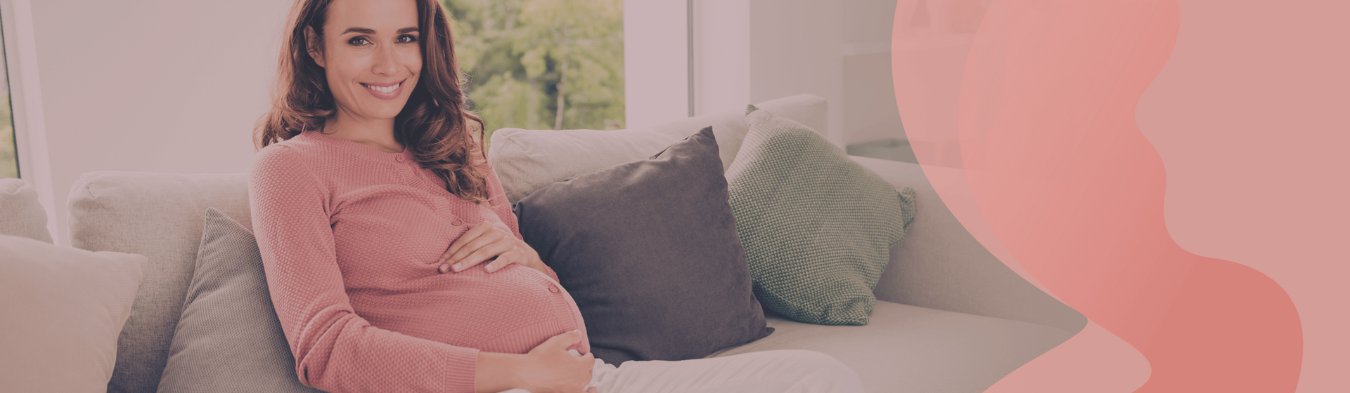 Pregnat woman sitting on a couch, holding her belly and smiling at the camera. Pregnat woman sitting on a couch, holding her belly and smiling at the camera.